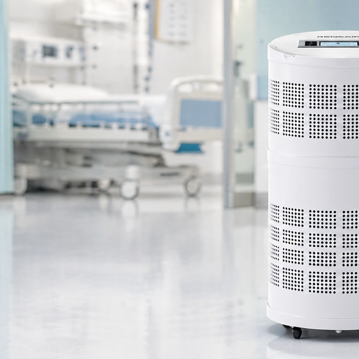 RENSAIR Q01B hospital-grade air purifier positioned in a bright clinical setting with hospital beds and waiting chairs in the background.