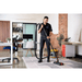 Person cleaning a carpeted office floor with a Cleanstar AS5 15L Commercial Plastic Dry Vacuum Cleaner and an activ8 powered floor tool 