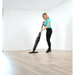 Person using a Cleanstar Dryft Floor scrubber on a wooden floor in a room with white walls.
