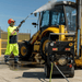Jetwave Hornet G2D 210-15 Diesel Powered Pressure Cleaner lifestyle action shot - man using jetwave hornet to clean yellow bulldozer