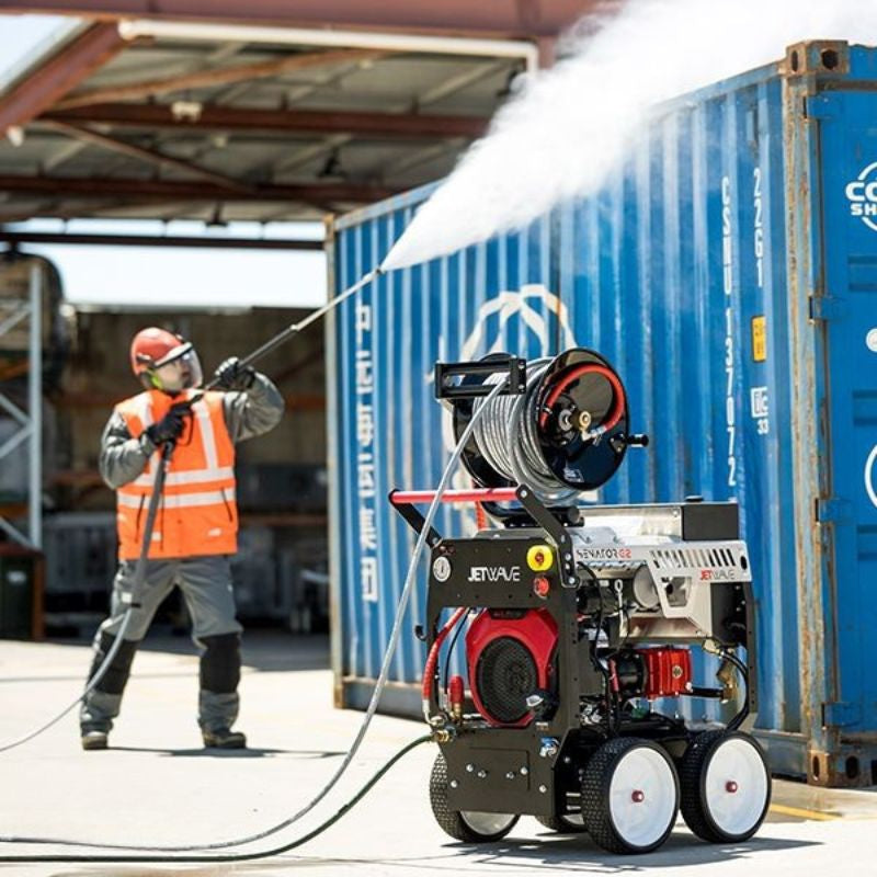 Jetwave Senator G2FI 280-31 Cold Water Petrol Pressure Cleaner blasting water onto a shipping container with a pressure washer.