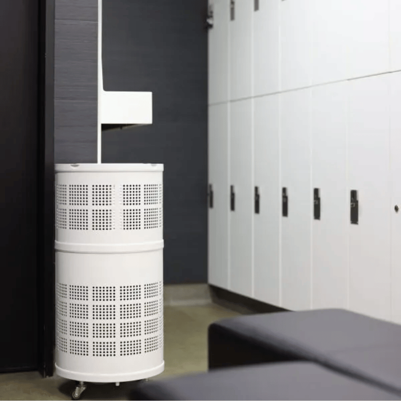 White Rensair Air Purifier with perforated design in a locker room setting.