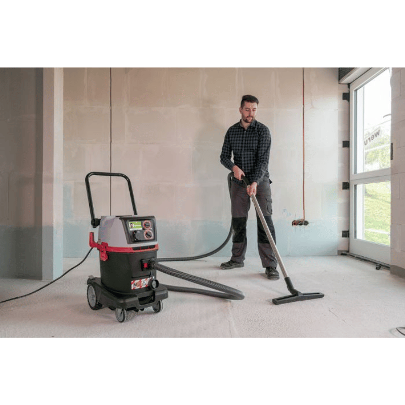 Person using a SPRiNTUS Craftix 35M M Class Commercial Vacuum Cleaner and brush in an indoor setting