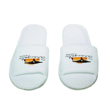 Pair of white Serengeti Collection hotel slippers with open toes and branded straps, displayed side by side against a plain white background.