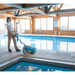 Person using a Tennant CS5 Micro Floor Scrubber by an indoor pool.