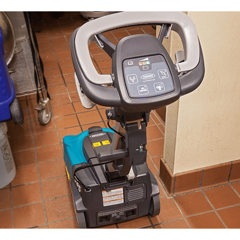 Tennant CS5 Micro Floor Scrubber with visible control panel on steering wheel on red coloured tiled area