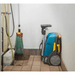 Cleaning equipment including a mop, pressure washer, and Tennant CS5 Micro Floor Scrubber in a bathroom.