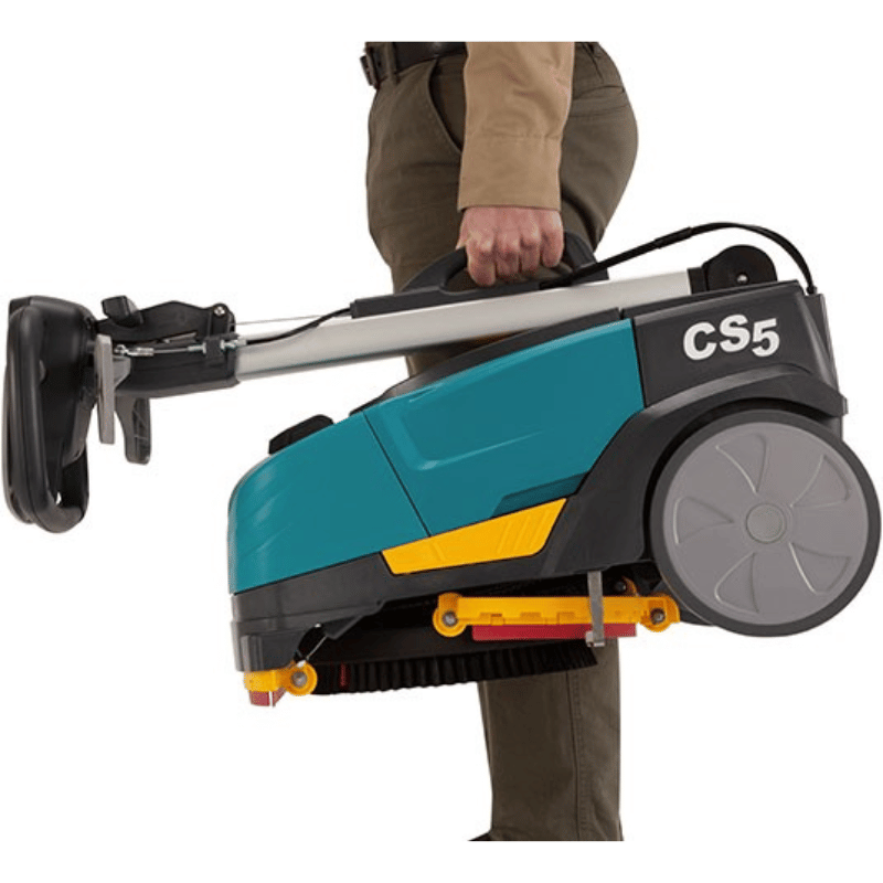 Tennant CS5 Micro Floor Scrubber being carried by a person whilst folded up on a blank white background 