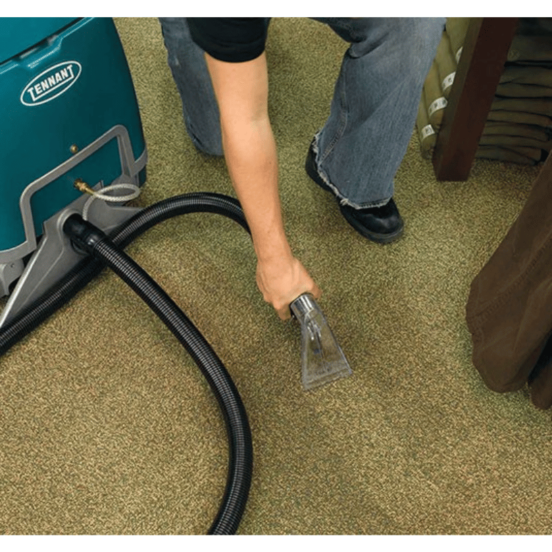 Tennant E5 Compact Walk Behind Carpet Extractor spotter upholstery tool being used by a person on a carpet floor