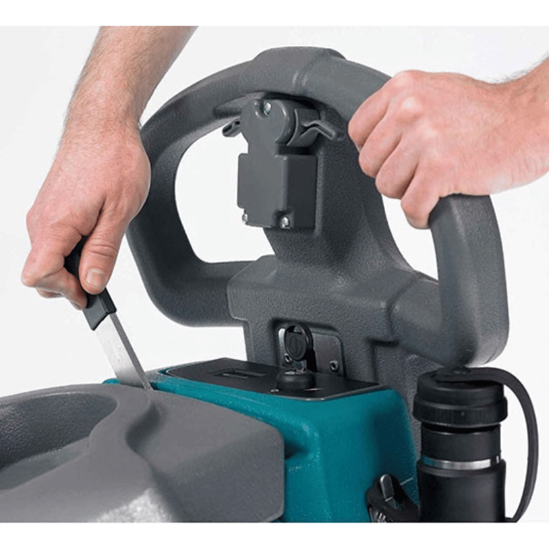 Tennant T2 Battery Walk behind Floor Scrubber close up view of a person holding the handle and using the machine