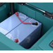 Close-up of a blue battery with red and black cables inside a teal coloured Tennant T360 walk behind floor scrubber