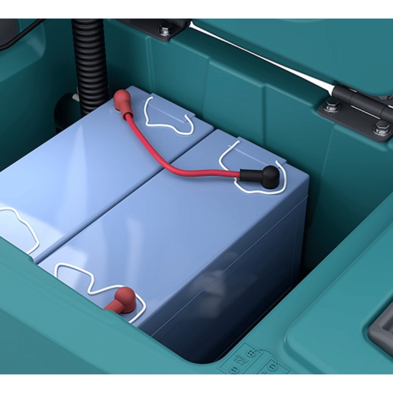 Close-up of a blue battery with red and black cables inside a teal coloured Tennant T360 walk behind floor scrubber