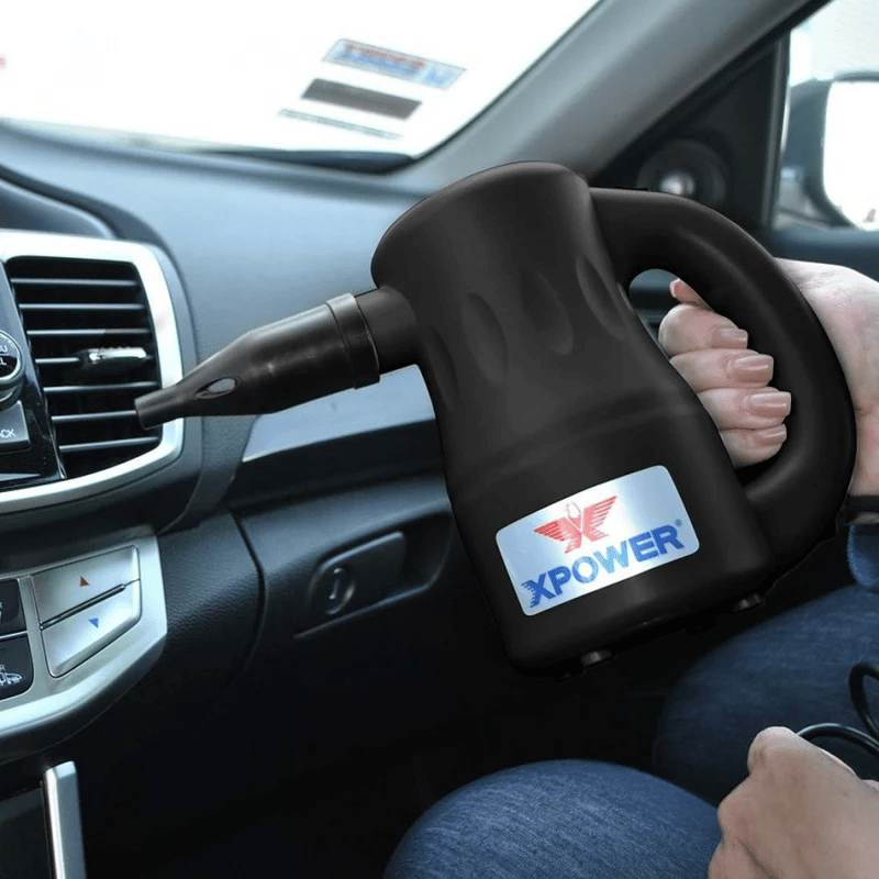 XPOWER Airrow Multipurpose Handheld Blower being used by a person in a vehicle to clean