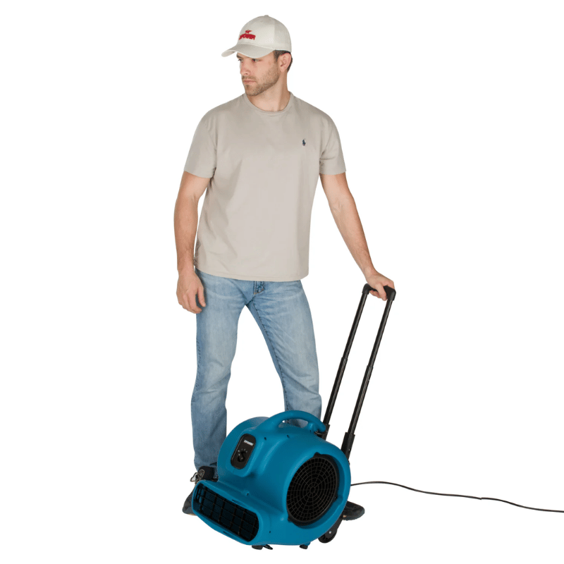 XPOWER X-800HC Heavy Duty Air Mover with wheels being used by a man on a white background