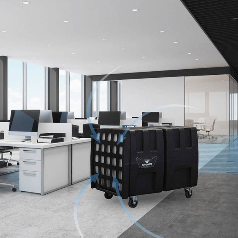 Xpower AP2000 High Volume Commercial Air Scrubber in a modern office setting with desks and large windows.